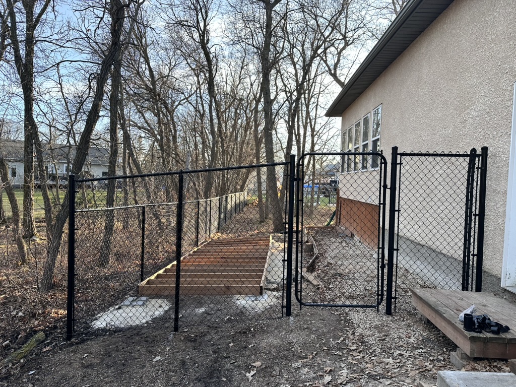 Black vinyl-coated chain link fence on sloping grade